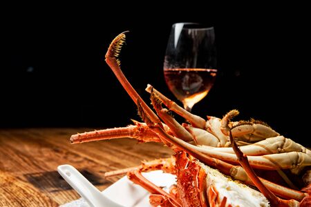Fabulous lobster dish on wooden table with wine and all the finesse of a luxury restaurant.の写真素材