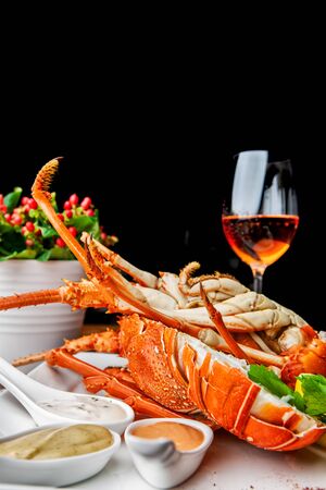 Fabulous lobster dish on wooden table with wine and all the finesse of a luxury restaurant.の写真素材