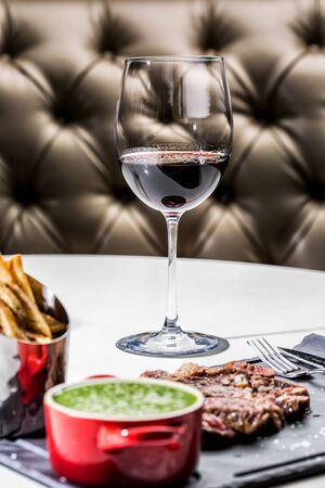 Gorgeous roast beef served with chips and a pan of asparagus with a glass of wine.の写真素材