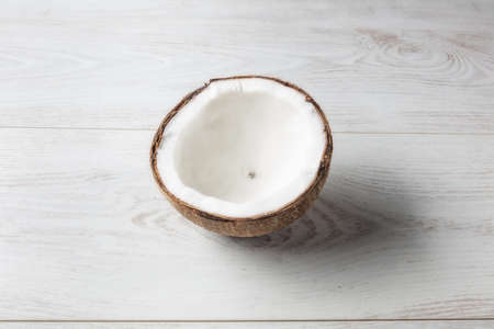 Coconut open in half seen from above with light wooden background.の写真素材