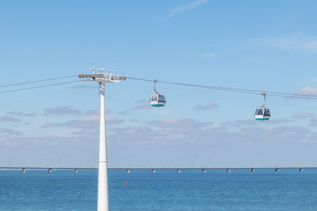 Cable car in Lisbon with the Vasco da Gama bridge in the background.