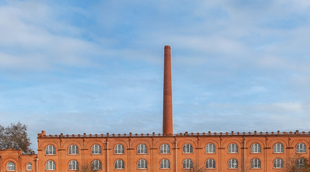 Old factory in orange brick with giant chimney.の写真素材
