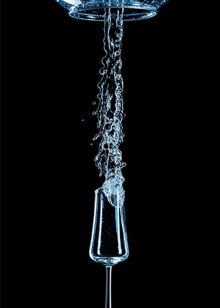 Water splash with inverted glass and black background.の写真素材
