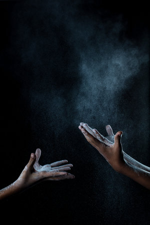 African man hands interacting with flour or powder.の写真素材