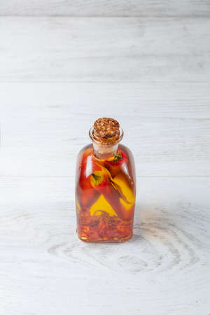 Spicy jar with chilli isolated on wooden background.の写真素材