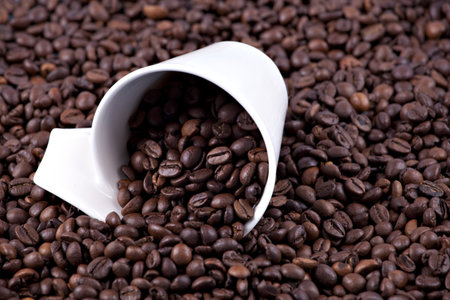Coffee beans dark roasted and white cup