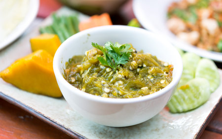 Thai Green chili dip with streamed vegetables on white place