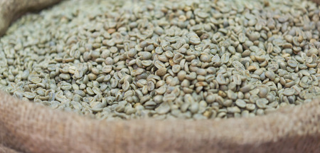 green unroasted coffee beans in canvas sackの写真素材