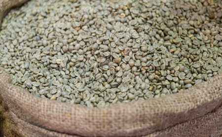 green unroasted coffee beans in canvas sackの写真素材
