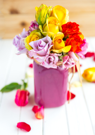 Colorful roses put in the purple vase or flowerpotの写真素材