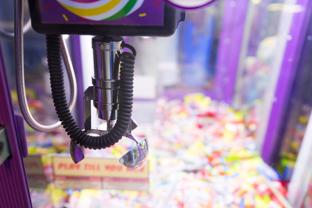 Mechanical arm selecting random toys in a vending machineの写真素材