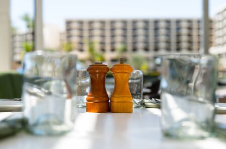 Wooden salt shaker and pepper mill on the tableの写真素材