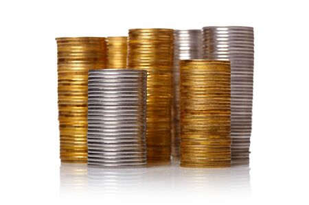 Golden and silver coin stacks over white backgroundの写真素材