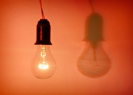 Photo of light bulb on red backgroundの写真素材