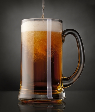 Mug of beer over black backgroundの写真素材