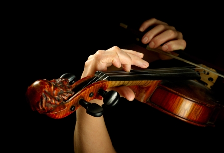 Musician playing violin isolated on blackの写真素材