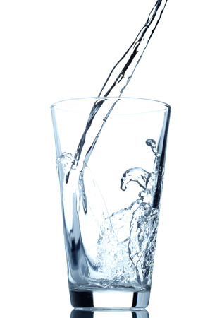 Pouring water into glass isolated on white backgroundの写真素材
