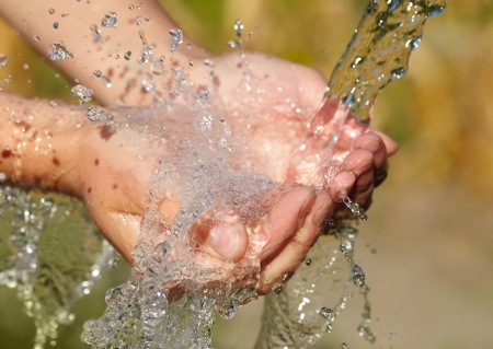 Woman's hands with water splash の写真素材