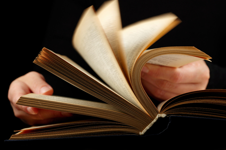 Looking thruogh book with motion blur on black 
backgroundの写真素材
