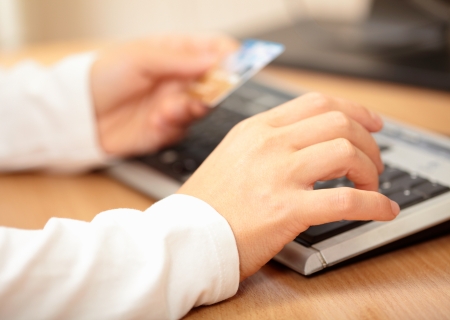 Hands holding credit card and keyboard. Shallow DOFの写真素材