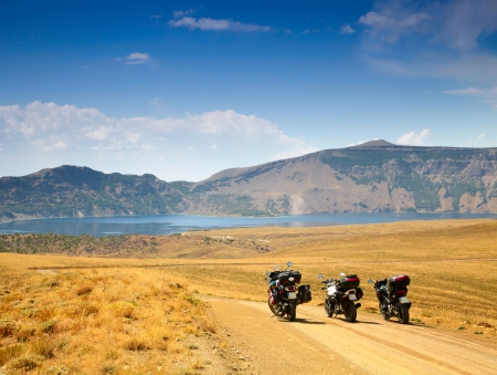 Landscape with mountain lake and three motorbikesの写真素材