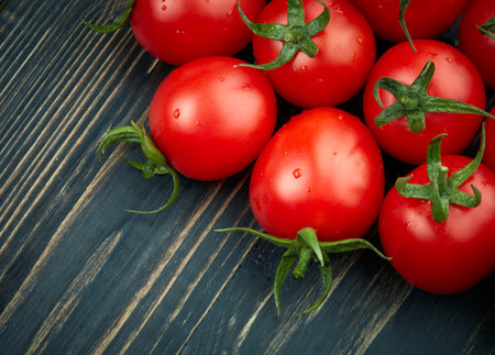 Ripe tomatoes on dark wooden backgroundの写真素材