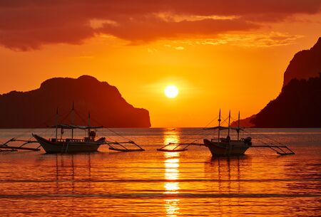 Traditional filippino boats at El Nido bay in sunset lights. Palawan island, Philippinesの写真素材