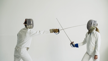 Two fencers having break after training attack exercises in fencing in studio indoorsの写真素材