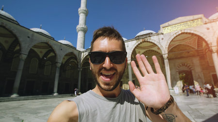 Handheld of Happy tourist man having online video chat using his smartphone camera near famous blue...