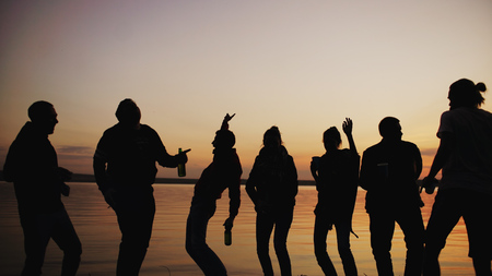 Silhouette of Group young dancing people have a party at beach on sunsetの写真素材