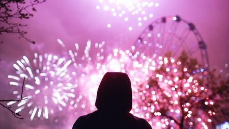 Closeup silhouette of alone man watching fireworks on new year celebration outdoorの写真素材