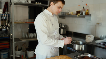 Professional chef man prepare gravy sauce with spices at restaurant kitchenの写真素材