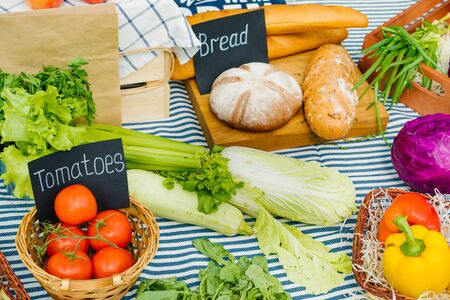 Fresh raw organic food vegetables fruit bread at autumn sale in farm market on beautiful table with wooden baskets. Nutrition and small business concept.の写真素材