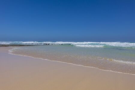 Breaking waves on golden sand on Corralejo beach in Canary islands, Spainの写真素材