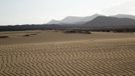 Sand pattern with mountains in the background, , Park Natural, Corralejo, Fuerteventura, Canary...