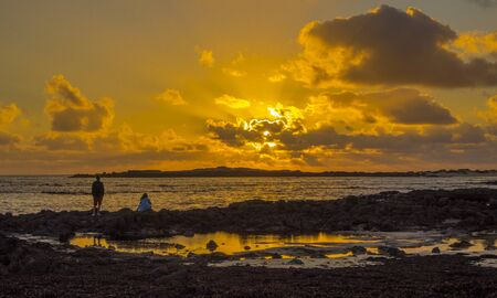 Sunset with dramatic colourful colorful sky in El Cotillo Fuerteventura Canary Islands Spainの写真素材