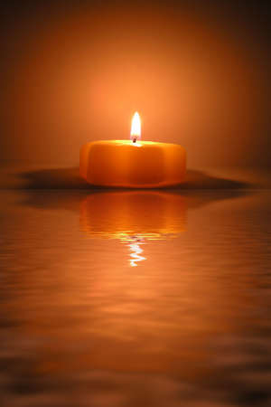christmas candle and reflection in waterの写真素材