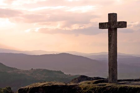 stone cross in mountain at sunsetの写真素材