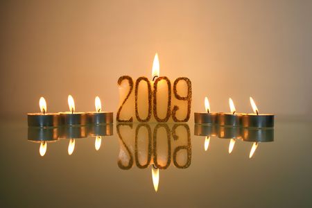 new year candles and reflection in glass tableの写真素材