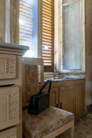 Italy, January 20, 2021. Handbag in a bedroom in an abandoned country villaのeditorial素材