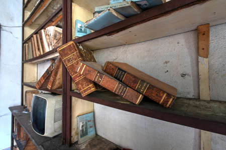 November 2020, Italy. Old books on a shelf of an abandoned dental office in Northern Italy. Urbex in Italyのeditorial素材