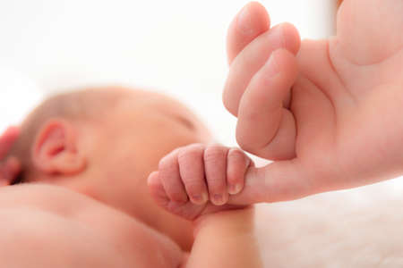 Italy, April 2021. The hand of a very small child holds the hand of the motherのeditorial素材