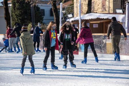 Bibbiano, December 2021. Young people skate on a small rink in the town squareのeditorial素材
