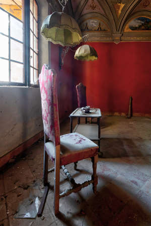 September 2021, Italy. Living room in an abandoned castle, with table, chairs and tea service. Urbexのeditorial素材