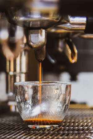 Close-up of espresso pouring from the coffee machine. Professional coffee preparationの写真素材