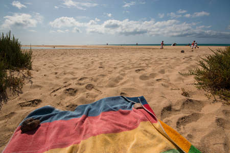 Desert beach view with colorful striped towel. Fuerteventura, Spain.の写真素材
