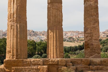 The columns of the Temple of "Castor and Pollux" with Agrigento city on the background. Temples Valley, Sicily.の写真素材