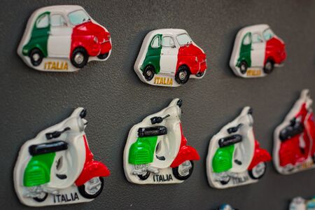 Souvenir magnets with typical italian cars and motocycles in italian flag colors on grey background.の写真素材