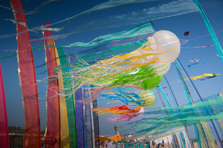 colorful wind ribbon lantern kites on the beach at Cervia international kite festivalのeditorial素材