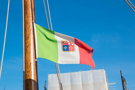 The italian army flag on a wooden boat flagpole on a sunny day in cesenatico.の写真素材
